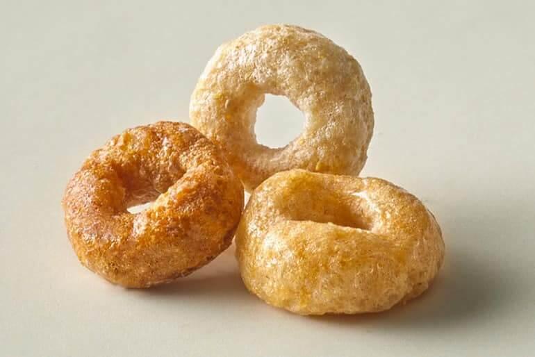 Three single Cheerios on a white surface